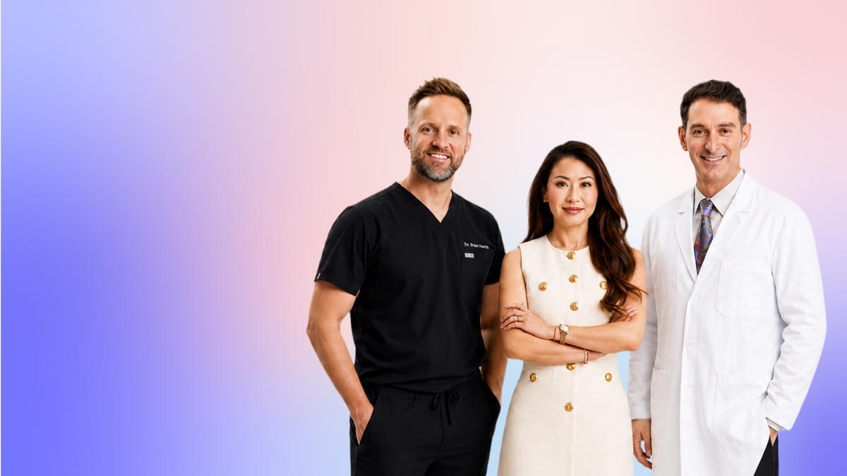 Two male and one female dentist standing beside one another smiling